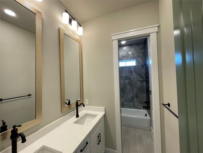 Bathroom with double vanity, shower combination, and wood finished floors | Image 26
