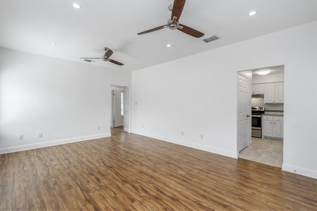 Unfurnished living room featuring a ceiling fan, recessed lighting, and light wood finished floors | Image 7
