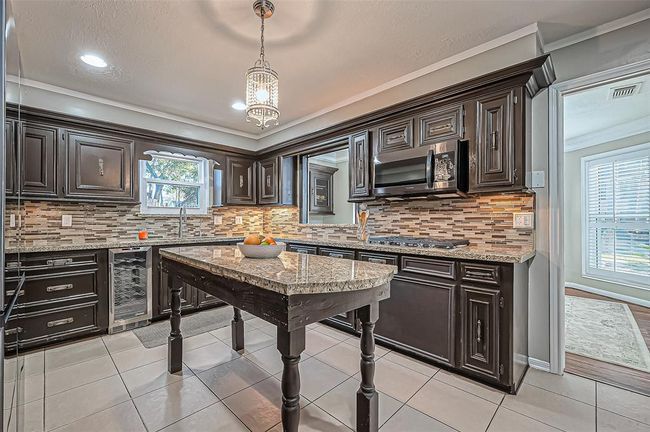 Enjoy sleek stainless appliances, complete with a wine refrigerator. | Image 18