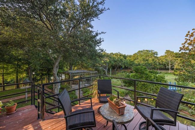 The open patio adjoining the second level living space presents a prime vantage point to savor breathtaking vistas of the grounds and the meandering river. This inviting outdoor setting serves as a front-row seat to nature's beauty, where residents can unwind, engage in conversations, or simply revel in the serene panorama that unfolds before them. | Image 18