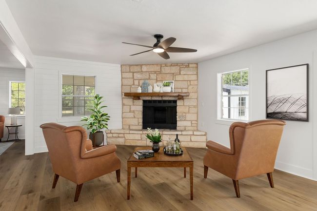 Cozy family room featuring a charming stone fireplace, elegant flooring, and abundant natural light—perfect for relaxation and gatherings. | Image 25