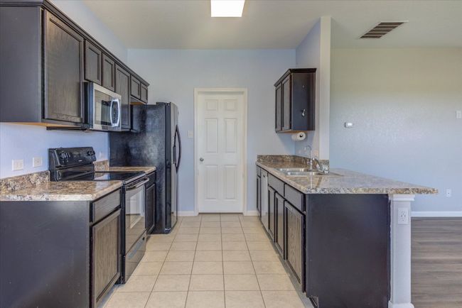 Kitchen with electric range, stainless steel microwave. Plenty of counterspace. | Image 9