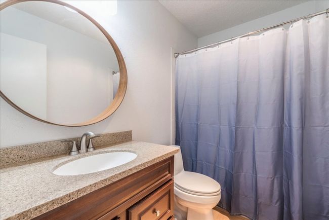 Full bath with curtained shower, toilet, vanity, and a textured ceiling | Image 13