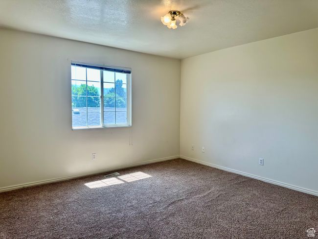 Spacious bedroom featuring a large window for plenty of light, carpet floors and baseboards | Image 20