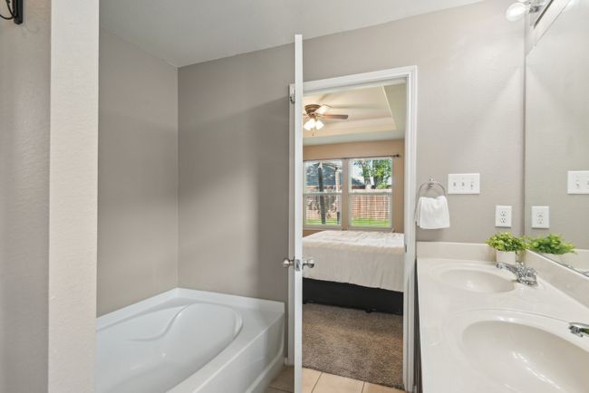 Full bathroom featuring tile patterned floors, a garden tub, a sink, and a ceiling fan | Image 27