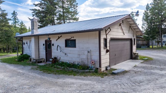 View of side of property featuring a chimney, a garage, and metal roof | Image 5