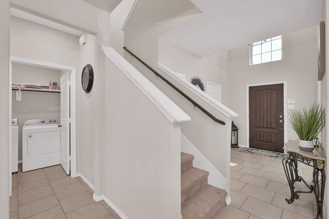 The laundry room is located to the left of the staircase. | Image 30