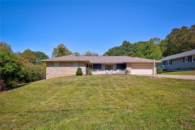 Ranch-style home with a garage and a front lawn | Image 1