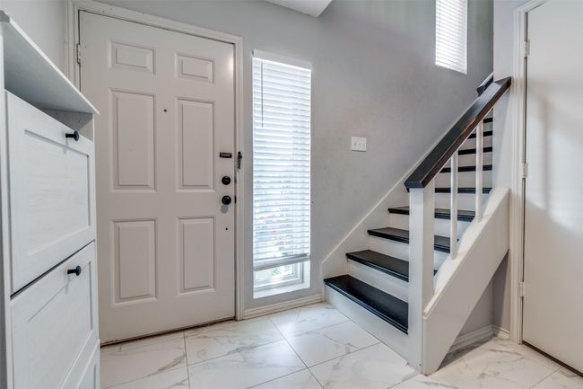 Foyer entrance with light marble finish flooring, stairs, and baseboards | Image 12