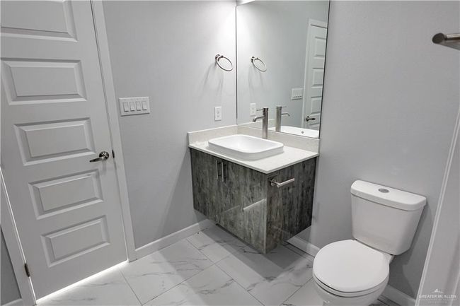 Half bathroom featuring marble finish floor, baseboards, toilet, and vanity | Image 17