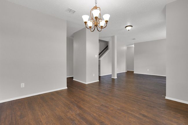 Unfurnished room with a chandelier, wood finished floors, and baseboards | Image 6