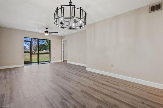 Unfurnished dining area with ceiling fan with notable chandelier and light hardwood / wood-style floors | Image 12