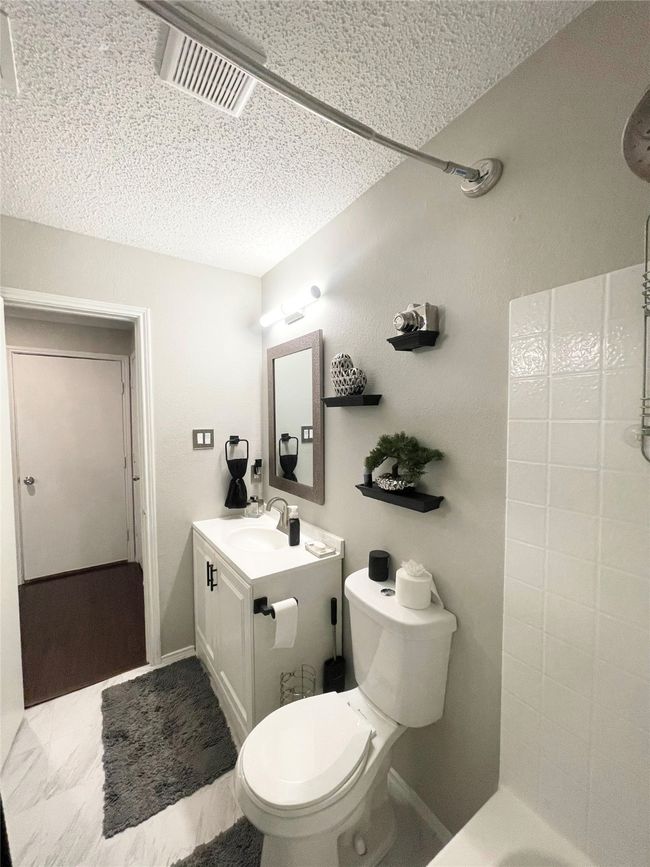 Full bath featuring a textured ceiling and vanity | Image 19