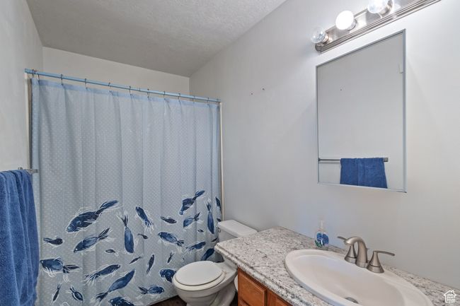 Bathroom with vanity, a shower with shower curtain, and a textured ceiling | Image 21