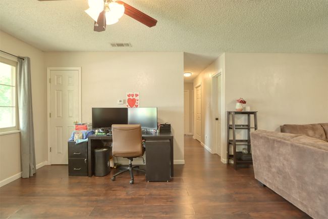 Office area featuring a textured ceiling, ceiling fan, and wood finished floors | Image 6