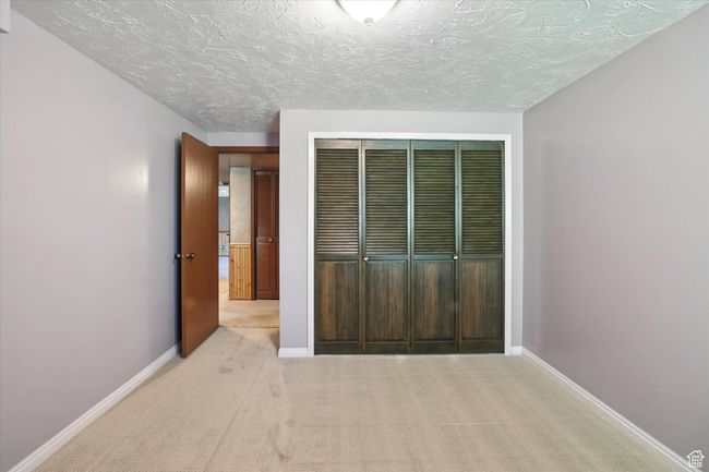 Carpeted basement bedroom with closet | Image 23