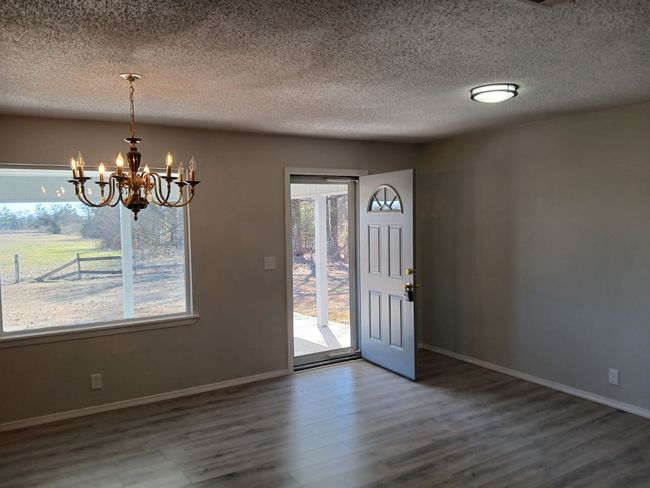 Entrance foyer with hardwood / wood-style flooring, a textured ceiling, and a chandelier | Image 8