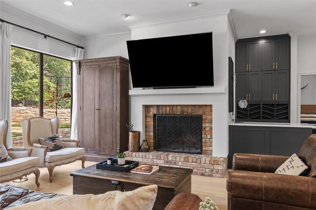 Living room with a brick fireplace, wood finished floors, recessed lighting, and crown molding | Image 16