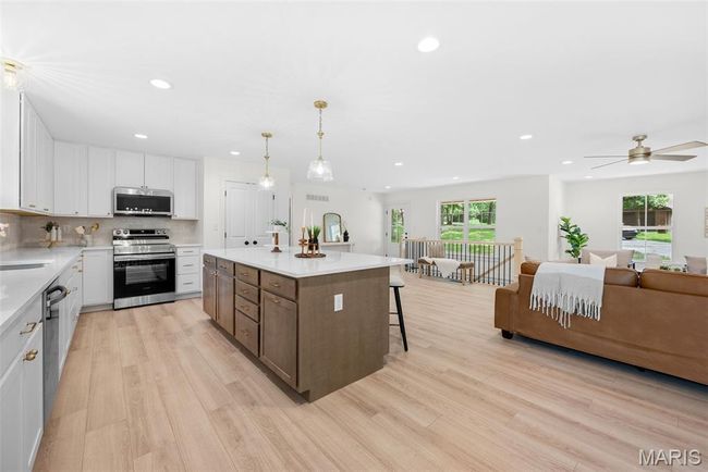 Kitchen with appliances with stainless steel finishes, recessed lighting, light wood-style floors, white cabinetry, and light countertops | Image 16