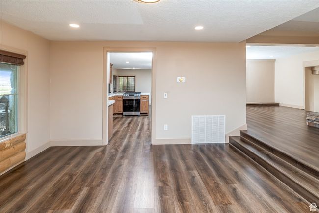 Spare room with dark wood-type flooring, a textured ceiling, and recessed lighting | Image 27
