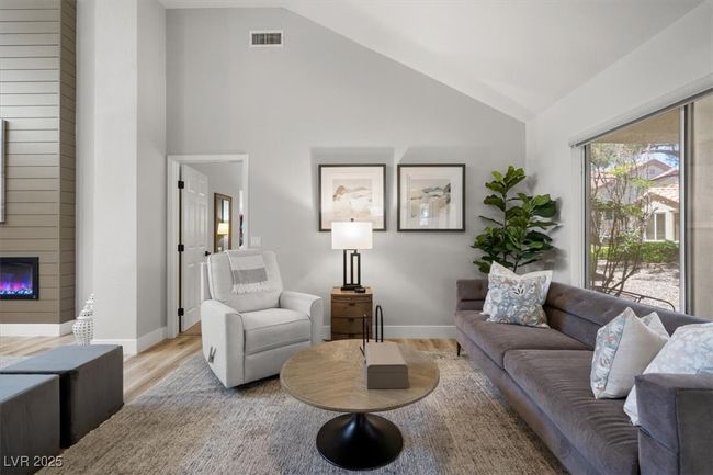Inside you'll discover soaring majestic ceilings, an open-concept floor plan, sleek pocket windows, & warm natural light. The upgraded interior features luxury flooring, fresh designer paint, & new baseboards. Relax by the linear fireplace or entertain in the formal dining area. | Image 20