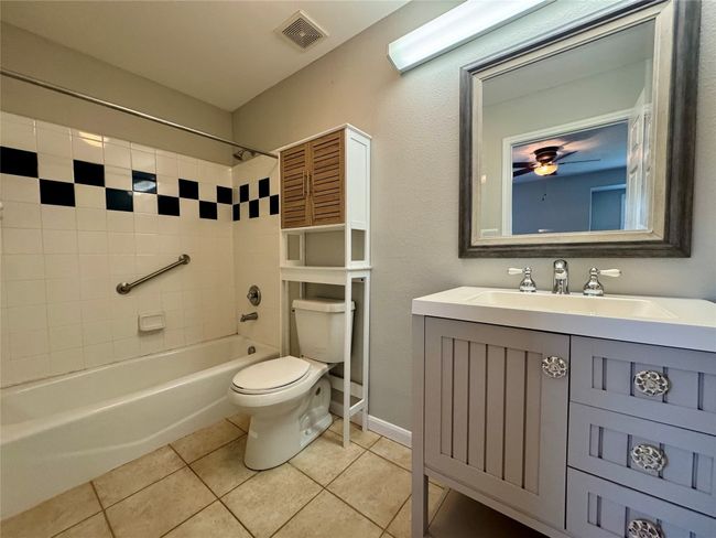 Full bathroom featuring tile patterned flooring, shower / washtub combination, and vanity | Image 13