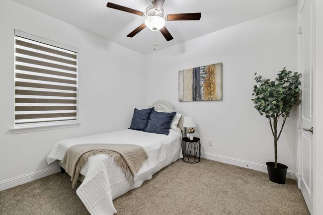 Carpeted bedroom with ceiling fan | Image 12