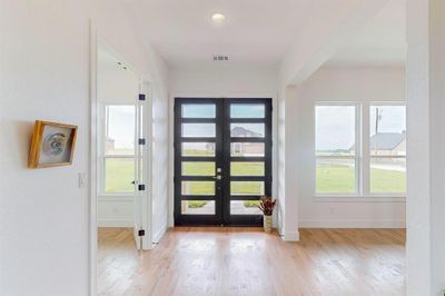 Foyer entrance featuring light hardwood / wood-style flooring, french doors, and a healthy amount of sunlight | Image 3