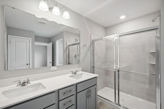 Primary bedroom with walk-in closet and private bath. Model home. Options and colors will vary. | Image 23