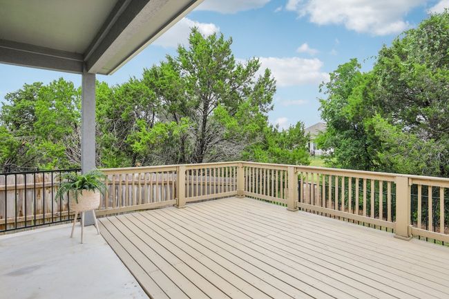 Huge extended deck off of the covered patio. Enjoy entertaining and relaxing with a view of the treed greenbelt. Perfect spot for bird watching! | Image 24