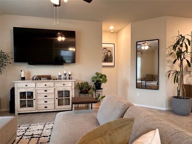 Tiled living area featuring ceiling fan and baseboards | Image 28