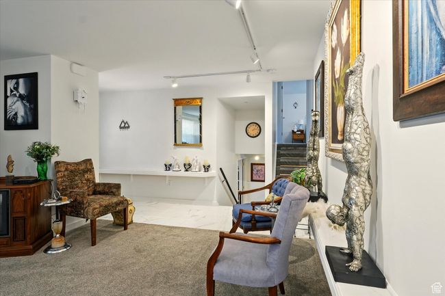 Sitting room featuring track lighting, stairway, and marble look tiles | Image 9