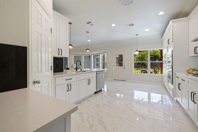 Kitchen with plenty of natural light and views to the back yard. | Image 10