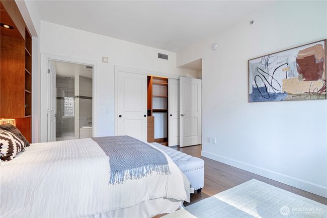 Master bed-Designed custom closet with ample hanging space, shelves, and drawers for organized and stylish storage. | Image 13