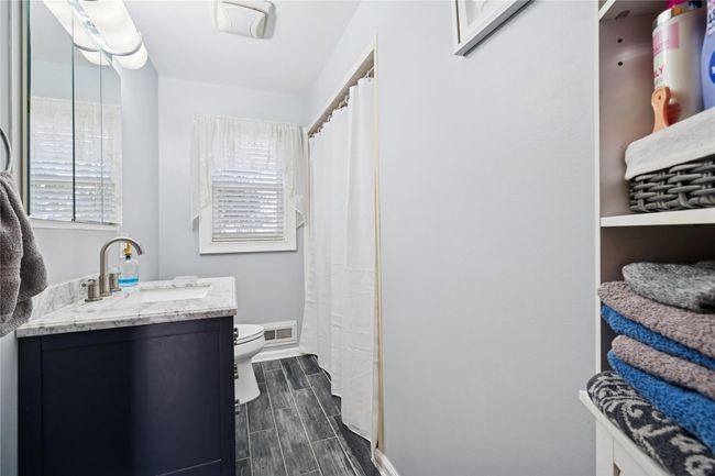 Full bathroom featuring wood finish floors, visible vents, plenty of natural light, and toilet | Image 32