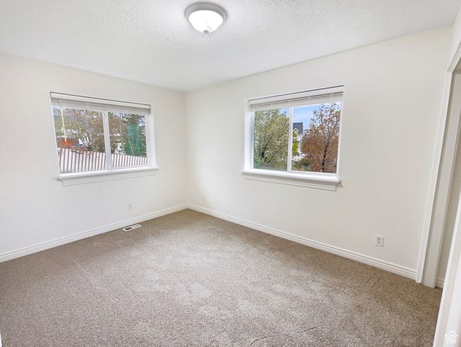Spare room with a textured ceiling, carpet, visible vents, and baseboards | Image 5