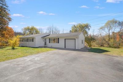 Single story home featuring a front lawn and a garage. | Image 2