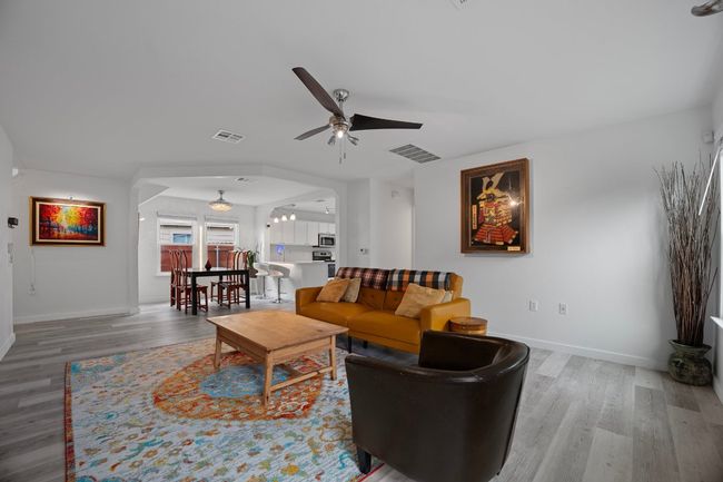 Living area featuring a ceiling fan and wood finished floors | Image 6