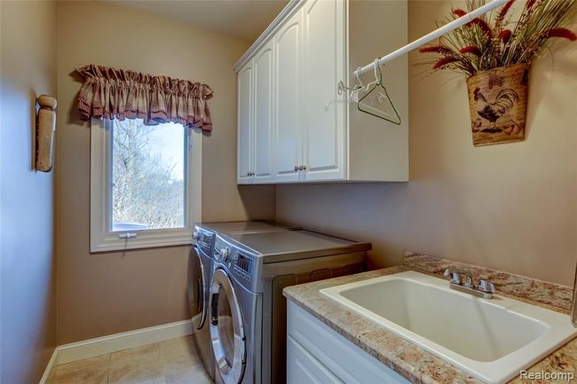 Entry level laundry room with storage, sink and granite | Image 22