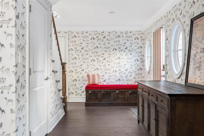 Foyer with dark wood-type flooring, wallpapered walls, stairway, and ornamental molding | Image 26