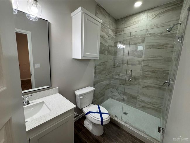 Full bath with toilet, wood finished floors, vanity, and a stall shower | Image 19