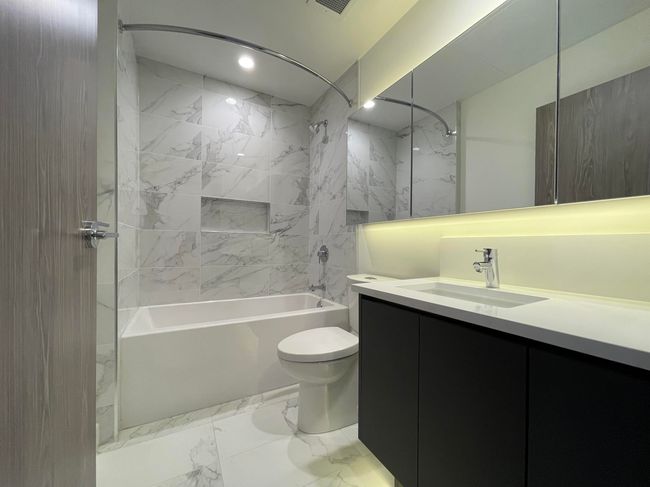 Full bathroom featuring recessed lighting, marble finish floor, toilet, vanity, and washtub / shower combination | Image 20