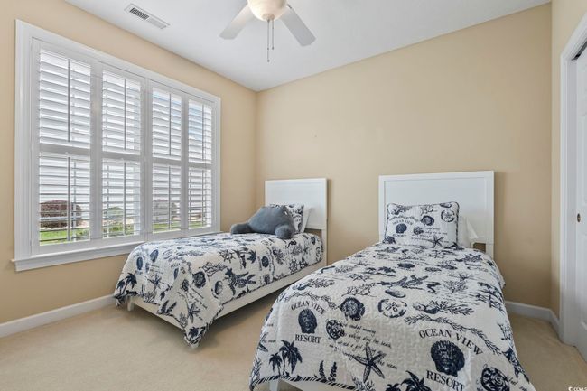 Carpeted bedroom featuring visible vents, ceiling fan, and baseboards | Image 17