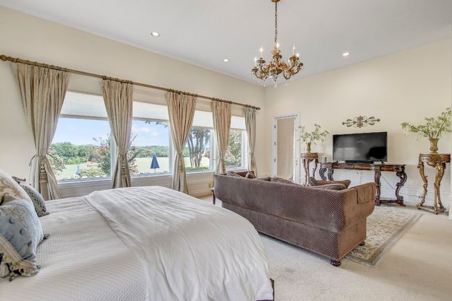 Carpeted bedroom with a chandelier, multiple windows, and recessed lighting | Image 21