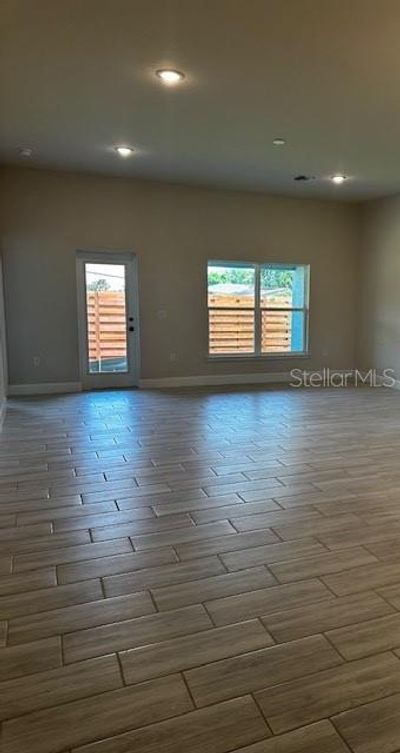 Beautiful living space with plank tile and lots of natural lighting. | Image 3