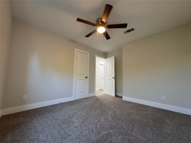 Spare room featuring visible vents, carpet floors, baseboards, and ceiling fan | Image 14