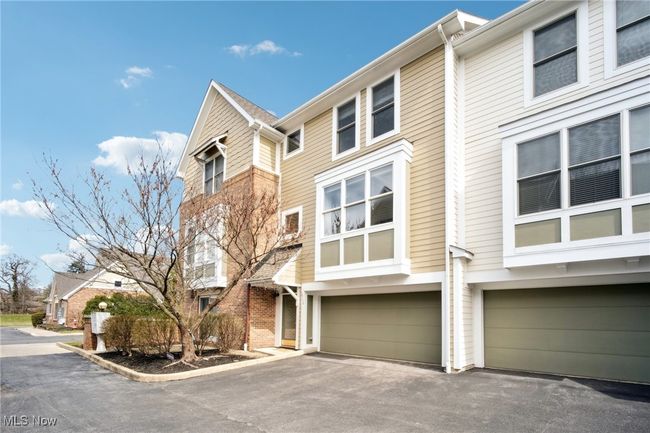 Townhome / multi-family property with aphalt driveway and an attached garage | Image 39