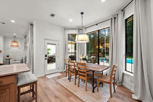 Just off the kitchen, the dining nook offers panoramic views of the backyard through large windows, with patio access for indoor-outdoor entertaining. | Image 17