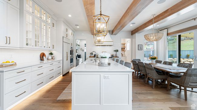 Kitchen featuring beam ceiling, a sink, light wood-type flooring, backsplash, and a chandelier | Image 22