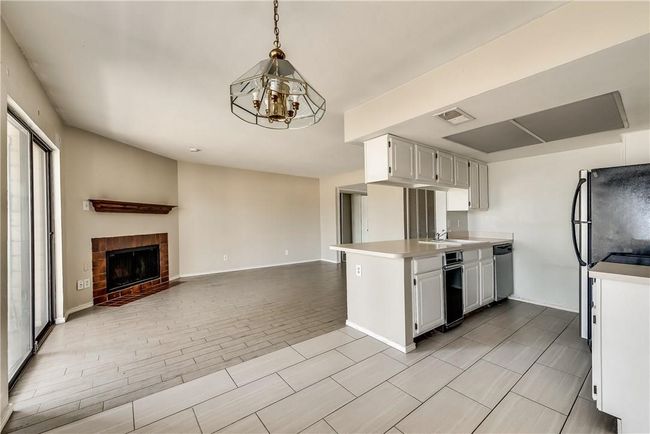 Kitchen with dishwasher, light countertops, a chandelier, open floor plan, and a peninsula | Image 5